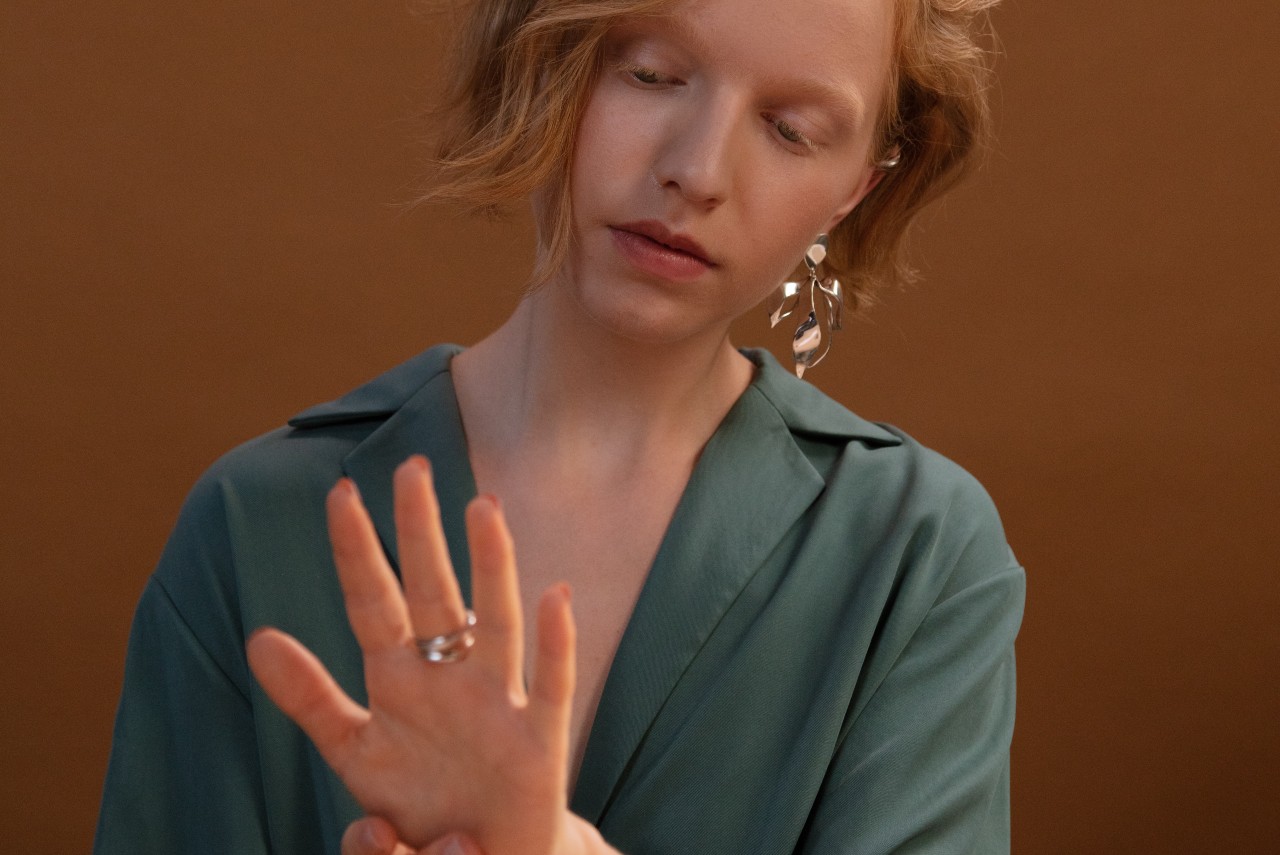 A redhead woman admiring two rings on her finger